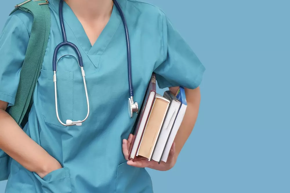 Studente universitario che studia le materie del semestre filtro Medicina tra libri di Biologia, Chimica e Fisica